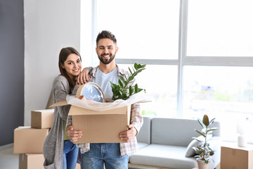 Young couple with belongings in their new house