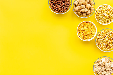 Cereals and flakes from corn and oat on yellow background top view mockup
