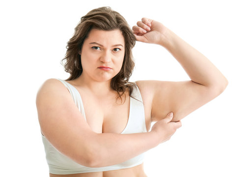Sad plus size woman in underwear on white background. Concept of weight loss
