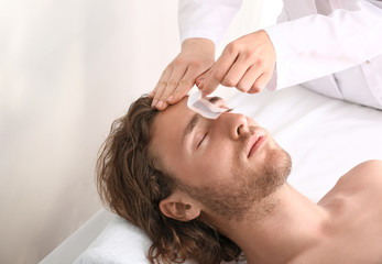 Obraz na płótnie Canvas Young man during epilation in beauty salon