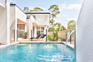 Luxury pool side near modern home entrance.