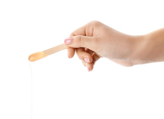 Female hand with sugaring paste on stick against white background