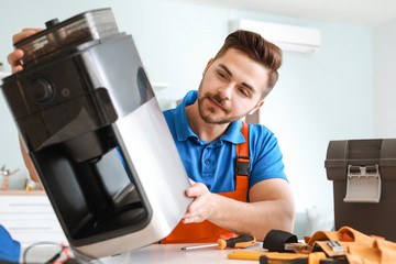 Man repairing coffee machine in kitchen