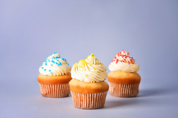 Tasty Birthday cupcakes on grey background