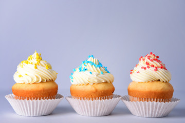 Tasty Birthday cupcakes on grey background