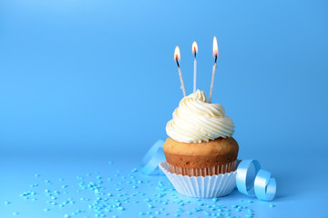 Tasty Birthday cupcake on color background