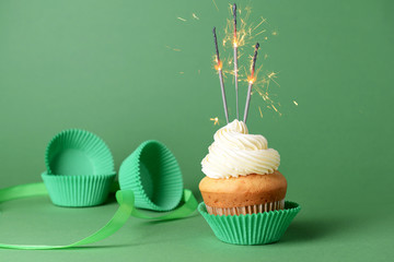 Tasty Birthday cupcake on color background