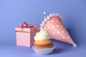 Tasty Birthday cupcake on color background