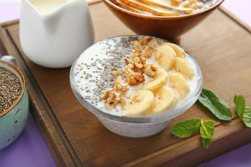 Bowl with tasty chia dessert on wooden board
