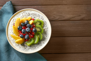 Bowl with tasty chia dessert on wooden table
