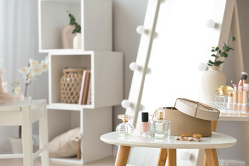 Table with accessories and cosmetics in modern makeup room