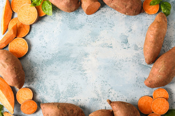 Frame made of raw sweet potato on color background