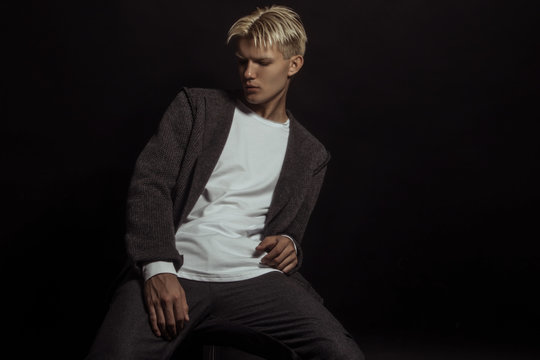 Handsome  blonde male model wearing smart casual cloath on black isolated font background