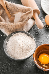 Flour with eggs on dark background