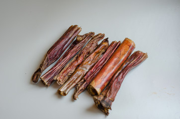 A small handful of bully sticks on a light background. Natural treats for dogs. Air dried chew....