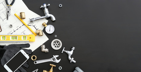 Mobile phone with plumbing items on dark background - obrazy, fototapety, plakaty