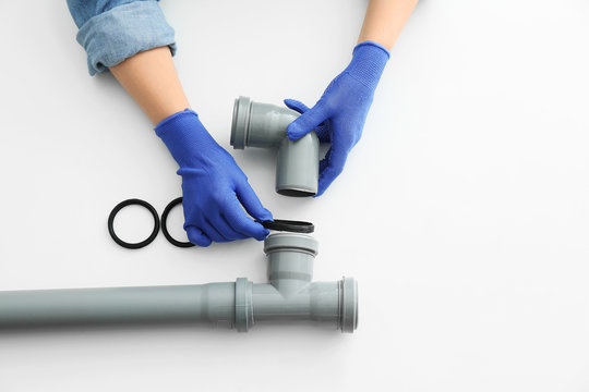 Plumber Working With Drain Pipe On White Background