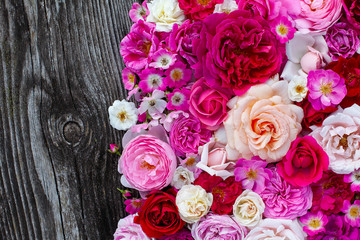 pink,red, violet and white roses on wooden surface