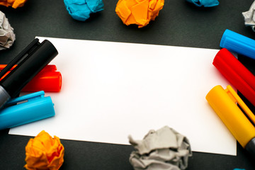Paper blank with colour pens and crumpled paper.