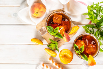 Iced tea and ingredients in glasses on wood background, copy space