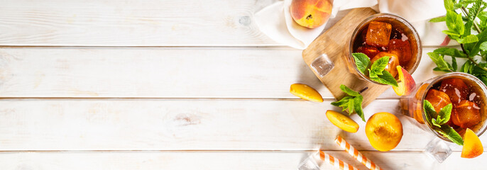 Iced tea and ingredients in glasses on wood background, copy space
