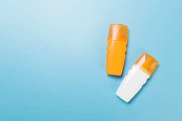 flat lay concept of summer travel vacation. Sunscreen bottle mock up on blue background top view with copy space