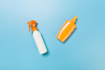 flat lay concept of summer travel vacation. Sunscreen bottle mock up on blue background top view with copy space