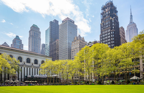 Bryant park, New York, Manhattan. High buildings view from below against blue sky background, sunny day in spring