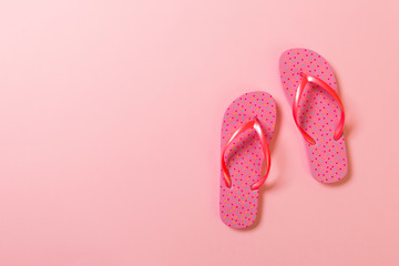 Coral flip flops on pink Background. Top view with copy space