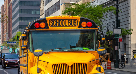 Yellow classic public school bus on the street, New York, Manhattan downtown.