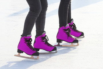 feet in pink skates on an ice rink. sports, Hobbies and recreation of active people.