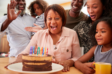 Multi-Generation Family Celebrating Grandmothers Birthday At Home With Cake And Candles