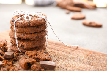 Tasty chocolate cookies on wooden board, closeup
