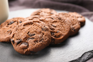 Tasty chocolate cookies on slate plate, closeup