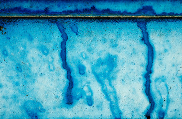 rustic blue plastered wall with stains of paint
