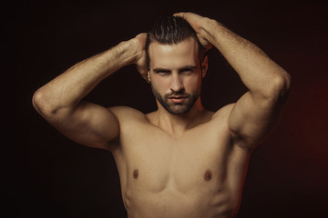Handsome sport sexy stripped guy portrait in a water draps and fog smoke mist on isolated black...