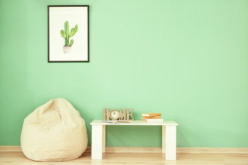 Modern table and beanbag near color wall