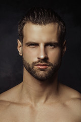 Handsome sport sexy stripped guy portrait in a water draps and fog smoke mist on isolated black background