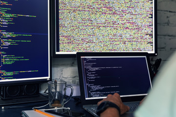 programmer web developer working on multiple computers