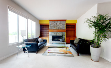 Modern home living room including large glass table with leather couch and fireplace
