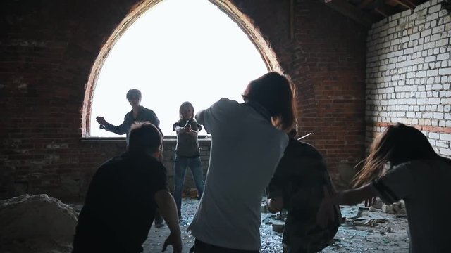 A zombie attack on the top floor of abandoned building. A man survivor tries to defend himself with a rock but he got bitten