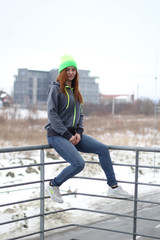 Girl with red hair in gray hoodie. Street style. Advertising brand clothing. Fashion Shooting