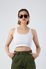 Asian Chinese Fashion influencer modeling in an army green pants and white tank isolated in white background