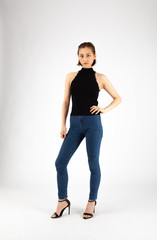 Asian Chinese Fashion influencer modeling in black top and tight jeans isolated in white background