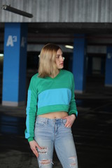 The girl is blonde in a green blue croptop. Street style. Advertising brand clothing. Fashion Shooting