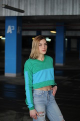 The girl is blonde in a green blue croptop. Street style. Advertising brand clothing. Fashion Shooting