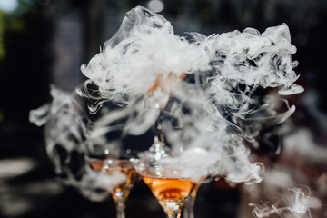 Smoke Over Martini Cocktail Glass Dry Ice Vapor. Bright Photo with Champagne Flute and Cool Effect....
