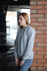 Girl  blonde  in grey hoodie. Street style. Advertising brand clothing. Fashion Shooting. Mockup.