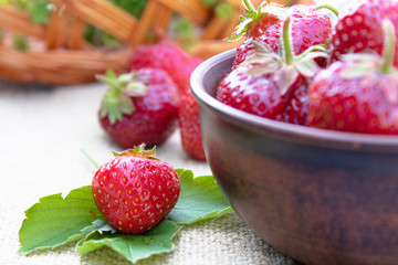 a bowl full of fresh strawberries on a burlap.
