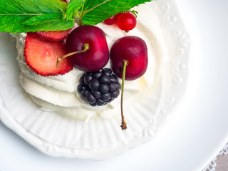 Pavlova cake with berries, cherry, blackberry, strawberry and mint